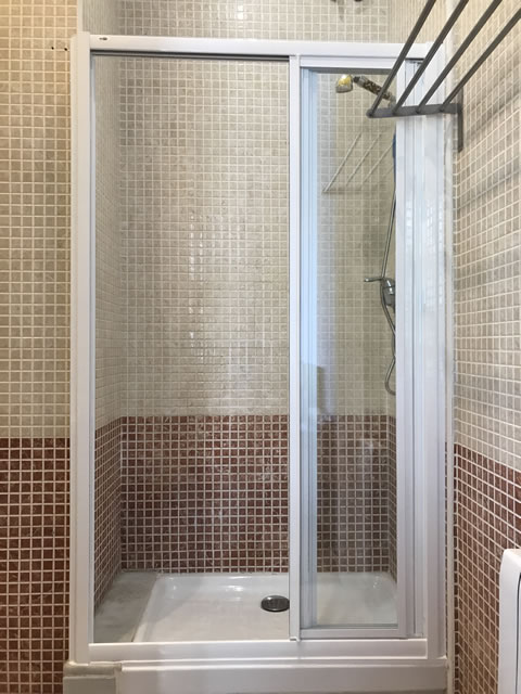 mampara en blanco y cristal transparente abierta