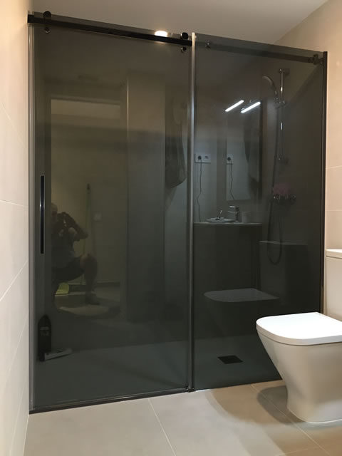 1 fijo + 1 puerta corredera perfil en cristal negro con tirador